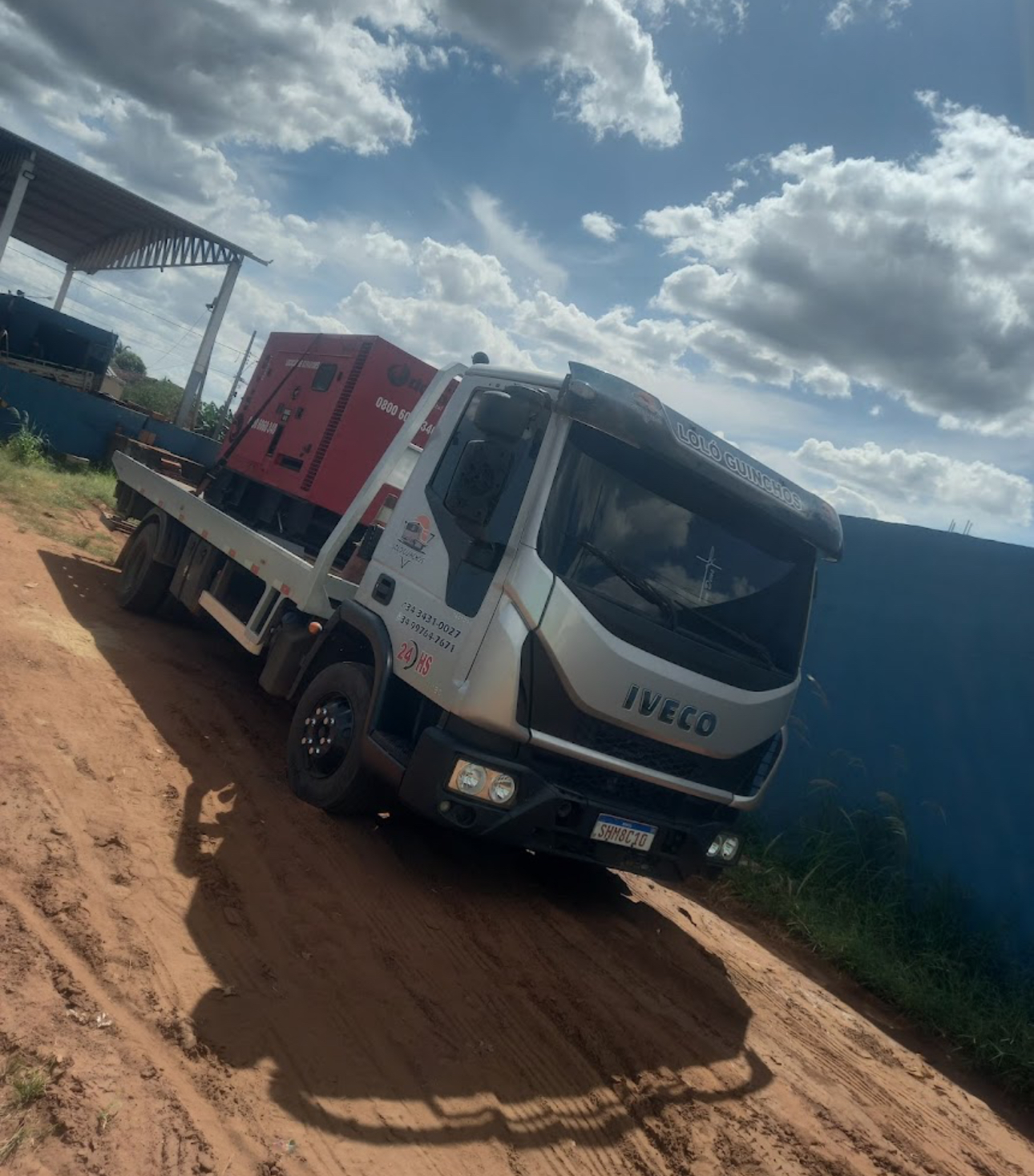 Caminhão plataforma da Loló Guinchos transportando equipamento pesado